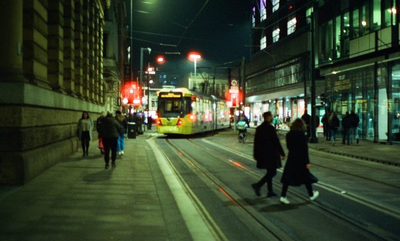 Image of a tram going through Manchester at night.