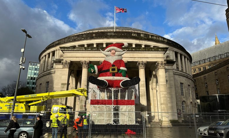 A giant sparkly Santa Claus figure sitting on top of giant wire box, in front of Manchester's Central Library