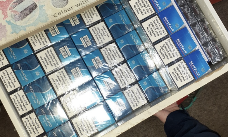 Image of packs of cigarettes stacked inside an open drawer.