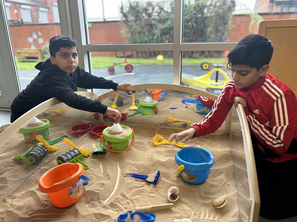 Brothers Hashim and Haider playing in a sandpit