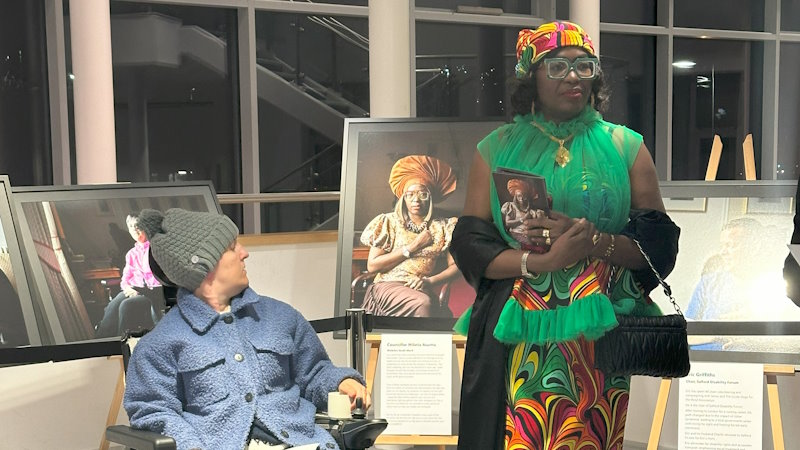 Two women stood in front of their portraits