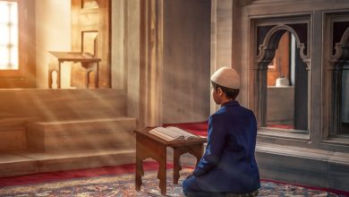 Photo Of A Muslim Person Kneeling In Front Of A Book