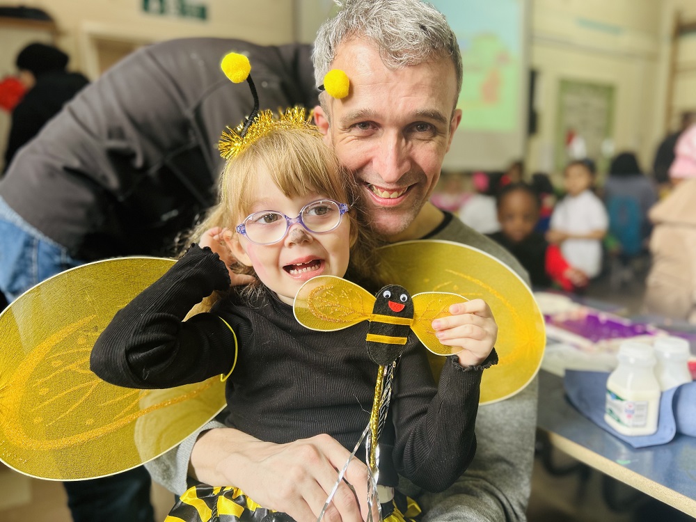 A happy father and daughter dressed up as a bee