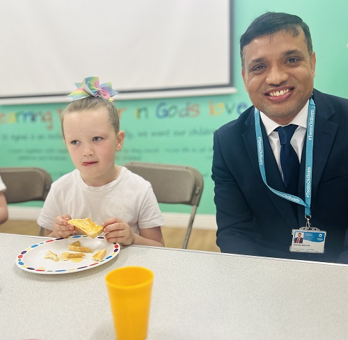 A pupil enjoying her breakfast as Cllr Mohon Ali visits the breakfast club