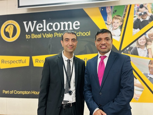 Headteacher Adil Rashid wit Cabinet Member for Education and Skills Cllr Mohon Ali standing in front of a 'Welcome' to Beal Vale sign