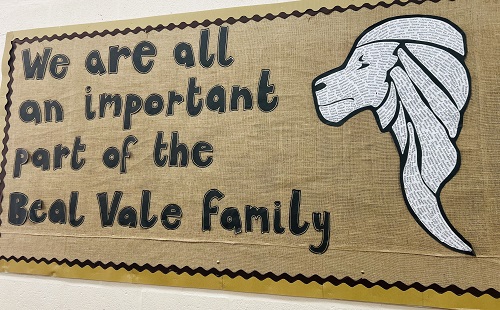 A sign in neutral colours with an image of a lion and the words 'We are all an important part of the Beal Vale Family'