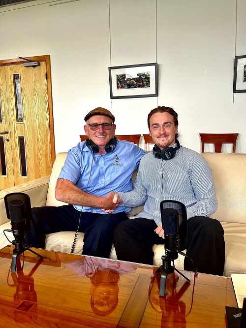 Frank Rothwell smiling in a blue shirt and flat cap as he shakes hands with podcast presenter Robin Marshall 