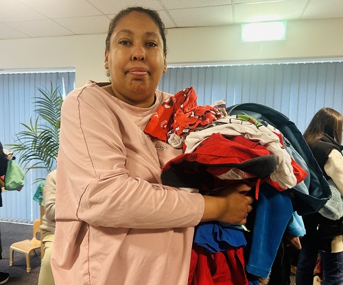 Dionne Hamilton holds the coats and clothing she got for her son at the drop-in