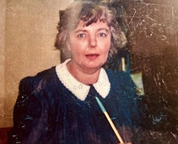 Mavis Clegg looking into the camera wearing an outfit with a white collar