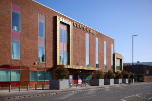 A picture of a large building with Gorton Hub sign at the top